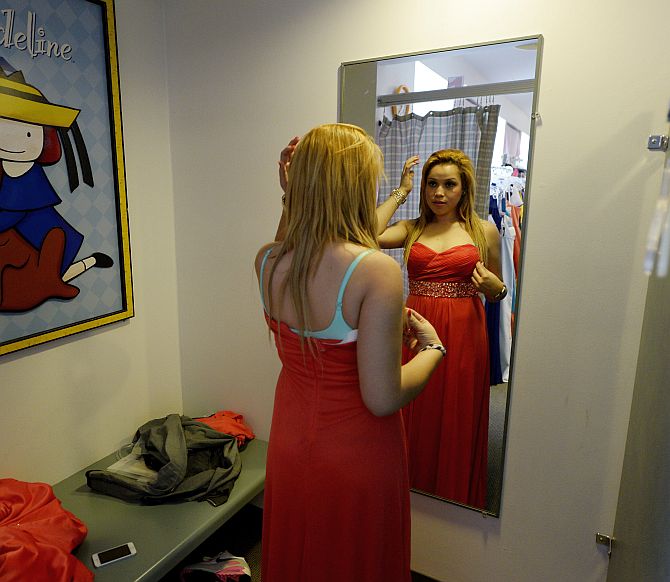 Marta Cruz, 17, from Helen Bernstein High School tries a prom gown.