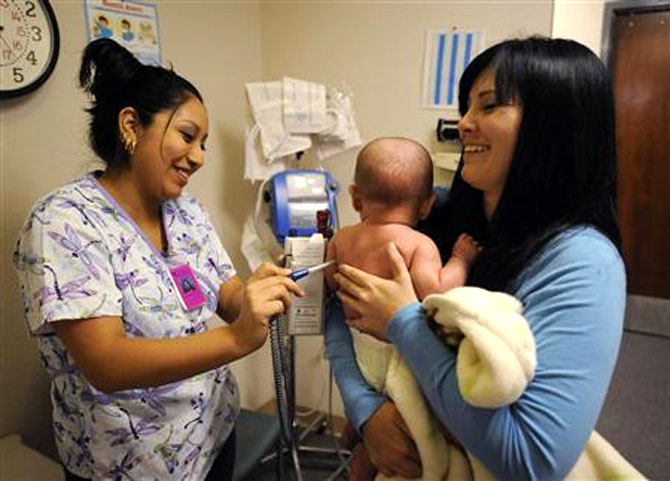 Certified nursing assistant Natalie Gutierrez (left) works with Ashley Ludwick and her baby Noah Gonzales at Sagebrush Clinic in Bakersfield, California.