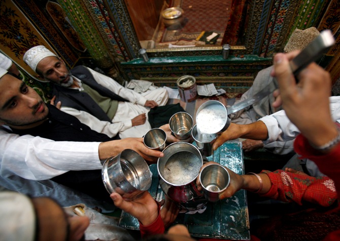A man distributes milk among Kashmiri Muslims before they break their day-long fast inside a Sufi shrine during Ramadan in Srinagar.