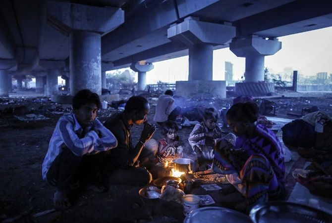 A migrant family prepares food below a flyover in Mumbai.