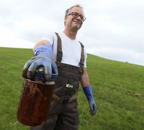 Denis Nadeau from Quebec holds crude oil in a jar.