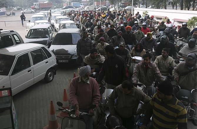 Motorists wait at a gas station to fill fuel in the northern Indian city of Chandigarh.