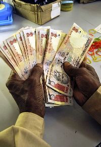 A man counts rupee notes.