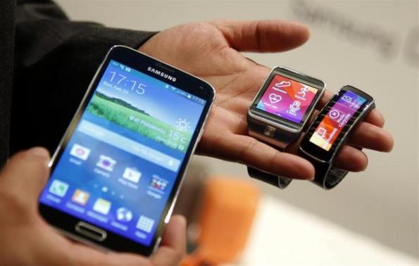 New Samsung Galaxy S5 smartphone (L), Gear 2 smartwatch (C) and Gear Fit fitness band are displayed at the Mobile World Congress in Barcelona February 23, 2014. 
