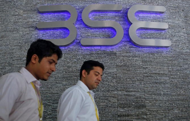 Two men come out of the Bombay Stock Exchange building.