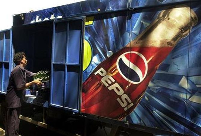 A worker loads crates of small Pepsi bottles in a truck in Mumbai.