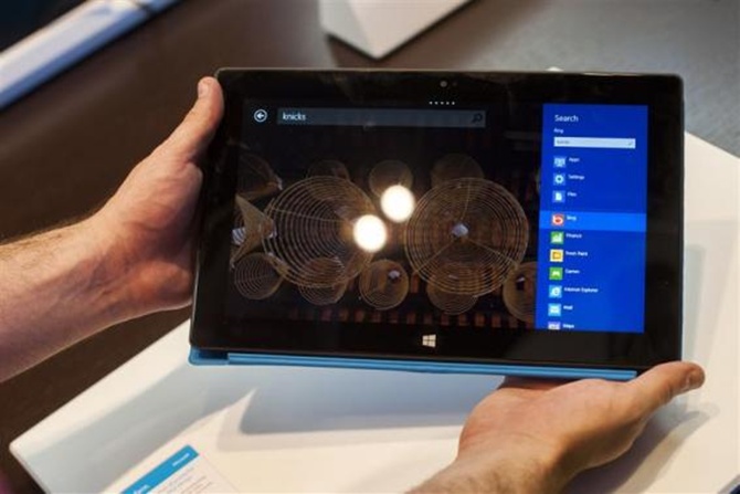 Sales staff demonstrate the Microsoft Surface during the opening of Microsoft's retail store.