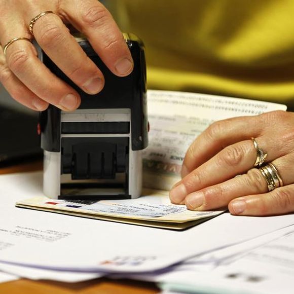 An immigration officer stamping a visa.