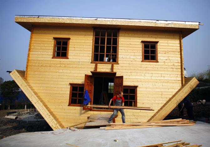 A labourer works at an upside-down house under construction at Fengjing Ancient Town, Jinshan District, south of Shanghai.