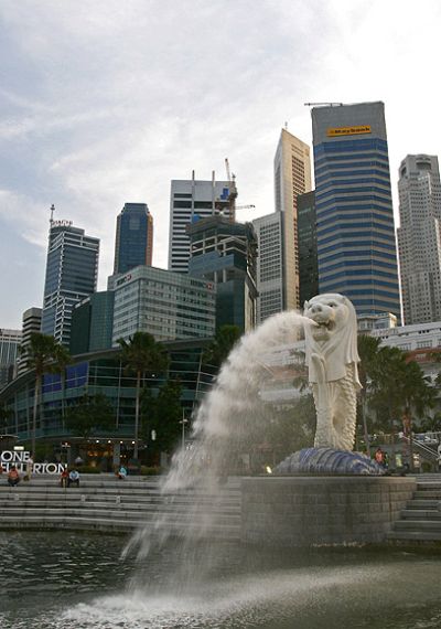 People sit on the steps near the Merlion, in Singapore's financial district June 10, 2009. Singapore's economy is expected to shrink at a slower pace in the rest of 2009 after a record annual contraction in the first three months of this year as analysts believe the worst might be over.