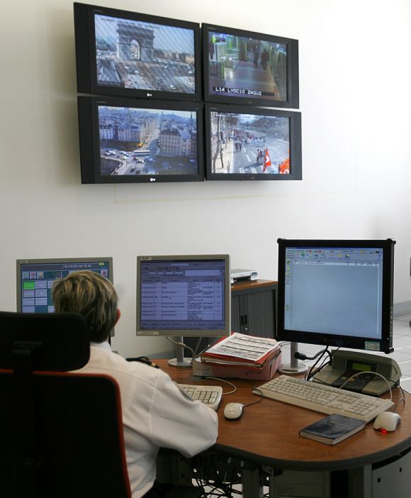 Police work near screens at the Paris Prefecture control room.