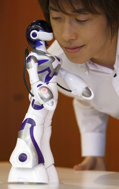 Sega Toy's female humanoid robot, Eternal Maiden Actualisation (E.M.A), kisses a man at its demonstration in Tokyo.