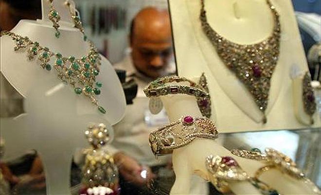 A shopkeeper arranges diamond jewellery in his stall at the India International Jewellery show, in Bombay.