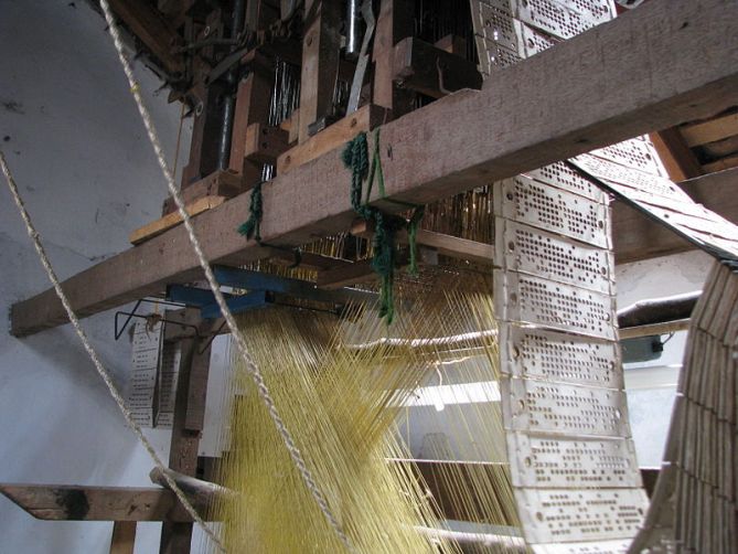 The complicated yet elegant pattern and string pulling system of a hand-loom to make fine silk saris.