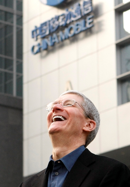 Apple Inc. CEO Tim Cook laughs outside a China Mobile store in Beijing.