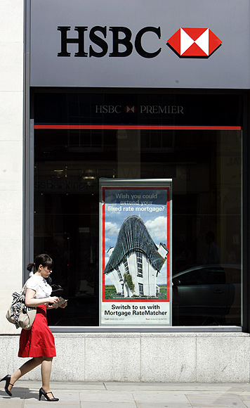 A pedestrian passes a branch of HSBC in London.