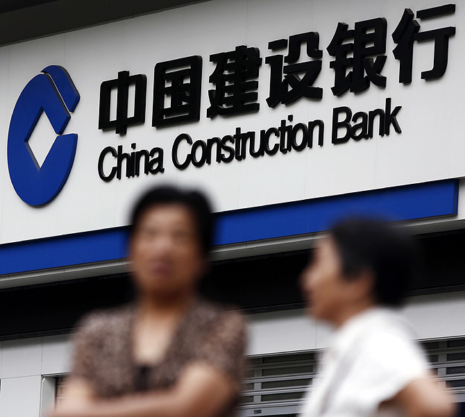 Residents stand outside a branch of the China Construction Bank (CCB) in Shanghai.