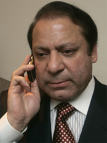 Pakistan's prime minister Nawaz Sharif speaks on his phone after a news conference in London.