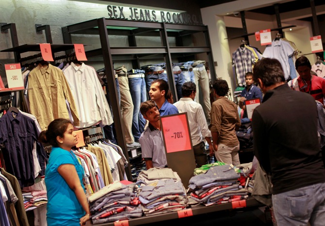 People shop for clothes at a store during a seasonal sale inside a shopping mall.