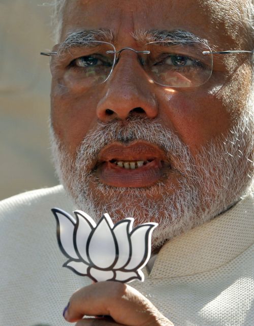 Hindu nationalist Narendra Modi, the prime ministerial candidate for India's main opposition Bharatiya Janata Party (BJP), holds a lotus cut-out after casting his vote.