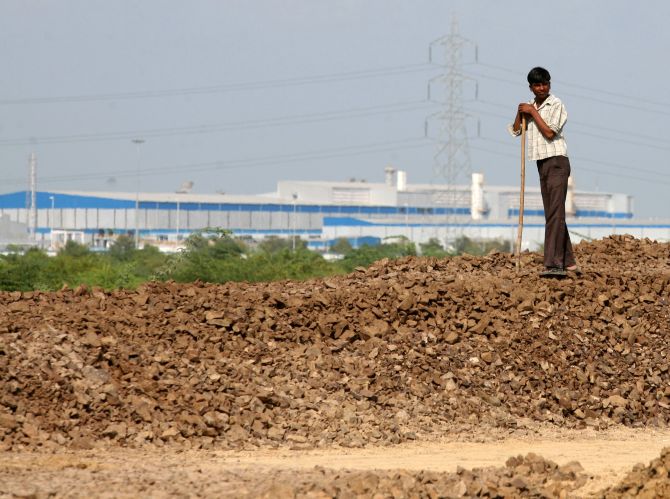 Govinda, 13, watches his cattle graze near the Tata Nano car plant in Sanand, Gujarat state.