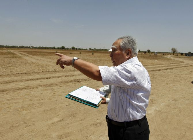 Suzuki Motor Corp's Osamu Suzuki gestures while checking a map during his visit to the construction site of a Maruti Suzuki plant at Vitthlapur village in the western Indian state of Gujarat.