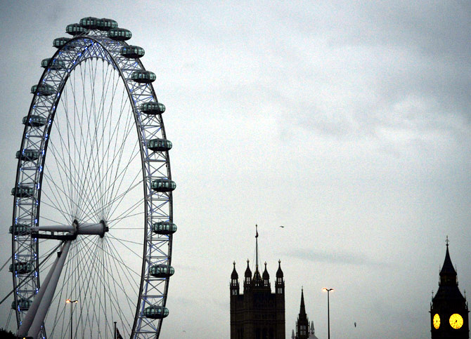 The London Eye is seen near the Houses of Parliament at dawn in central London.