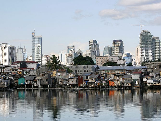 A shanty town is seen in front of the skyline of Manila's financial district of Makati City March.