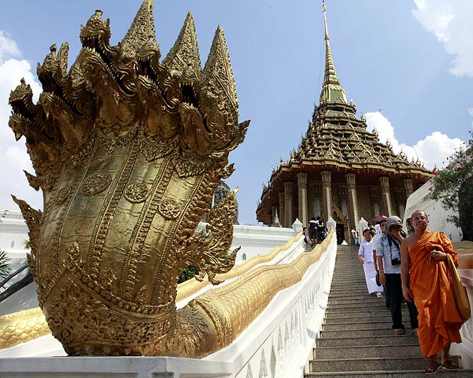 A Buddhist monk and people walk down a stairs during their visit at Wat Phra Phutthabat in Saraburi province.