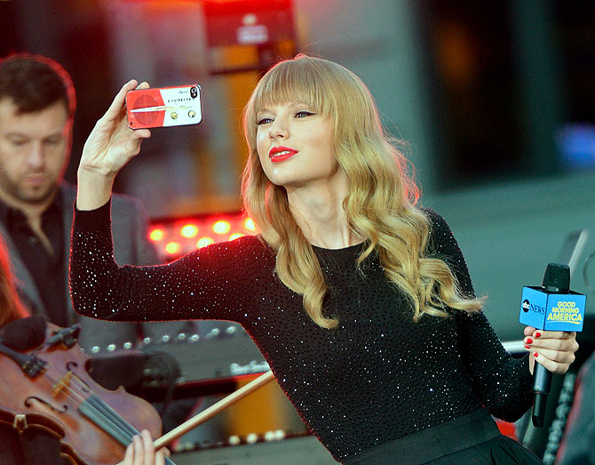 Singer and songwriter Taylor Swift takes a picture with her iPhone while peforming at ABC News' Good Morning America Times Square Studio.