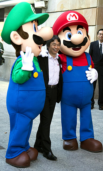 Japanese video game Designer Shigeru Miyamoto poses with men dressed as Mario Bros characters during a tribute in Gijon.