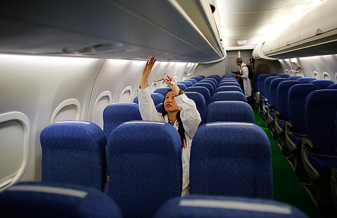 A journalist takes a picture with her mobile phone inside a ARJ21-700 aircraft.
