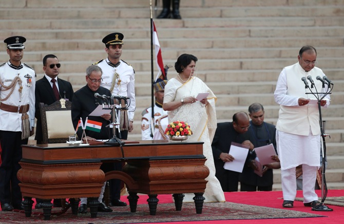 President Pranab Mukherjee (3rd L) administers the oath of office to Arun Jaitley (R) as a Cabinet minister at the Rashtrapati Bhavan in New Delhi May 26, 2014.