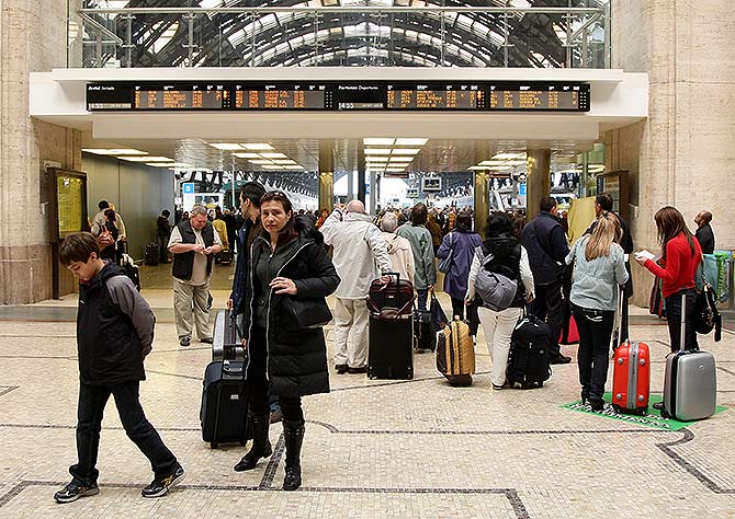  Passengers look at the departures board at Milano Centrale train station.