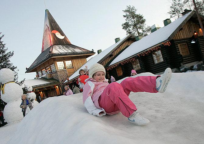 A child slides on snow in front of the Santa Claus' Office in Santa Claus' Village on the Arctic Circle near Rovaniemi, northern Finland.