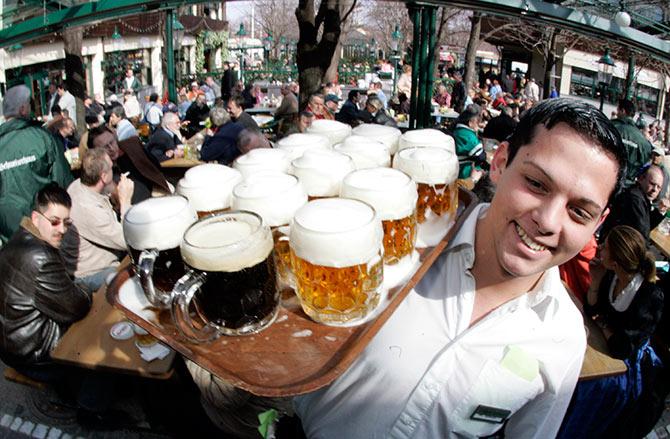 A waiter serves beer at the season opening of Vienna's Schweitzerhaus, a traditional beer garden at Vienna's amusement park 'Wurstl Prater'.