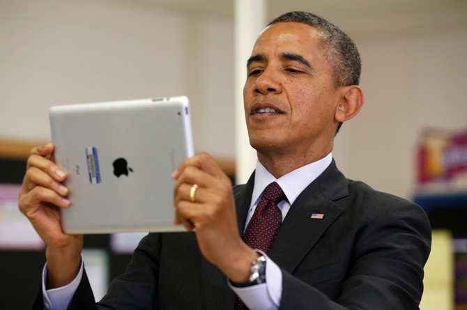 US President Barack Obama holds up an Apple iPad during a visit to Buck Lodge Middle School in Adelphi, Maryland.