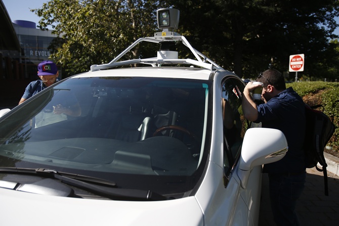 Attendees peer into a Google self-driving vehicle at the Computer History Museum in Mountain View, California.