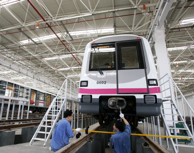 Technicians service a train in a station during a media visit to the new Shanghai Metro Line.