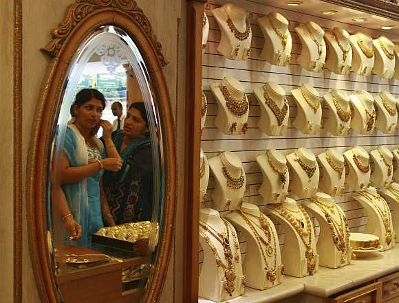 A woman tries a gold earring inside a jewellery showroom in Kochi.