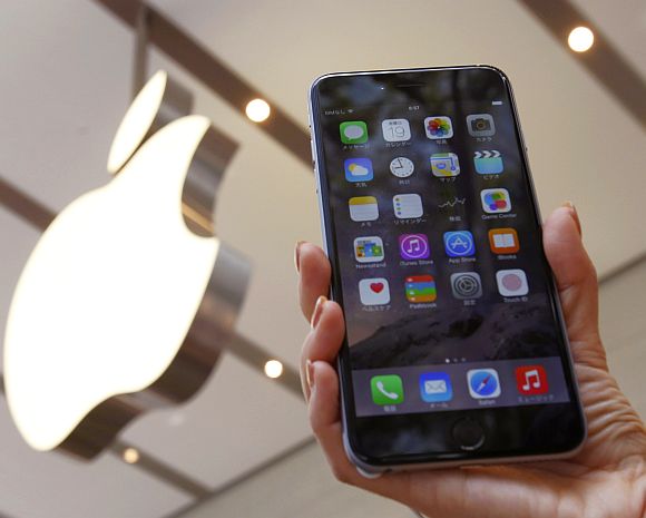 A woman holds up the iPhone 6 Plus at the Apple Store.