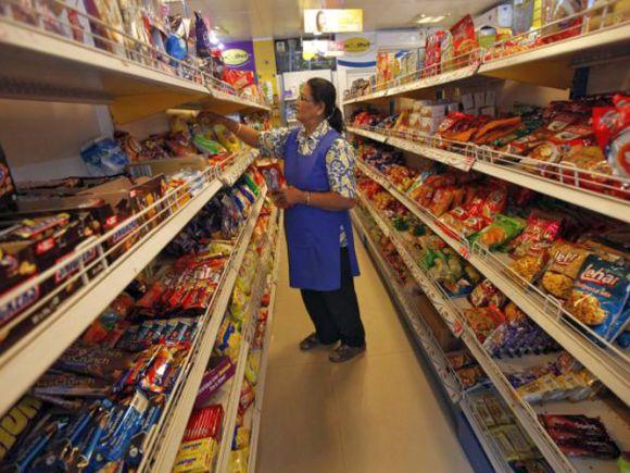 A worker arranges food packets inside a retail store in Kolkata.