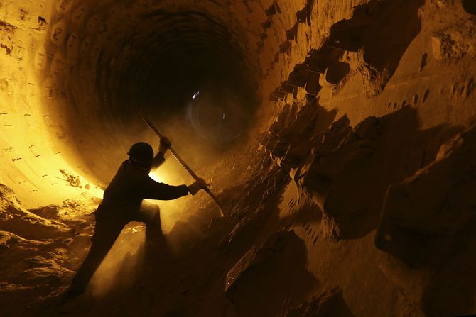 A worker cleans a furnace pipe at a cement plant.