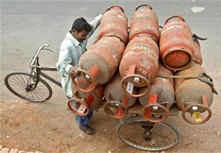 A vendor loads LPG gas cylinders for delivery