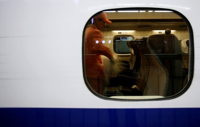 A worker cleans the inside of a bullet train at a railway station in Tokyo.