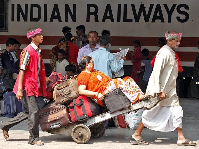 Porters ferrying a passenger at a railway station in India.