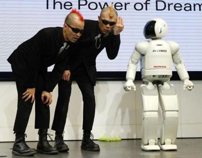 Japan's mime artists HIRO-PON and Ketch performs with Honda Motor's humanoid robot Asimo.