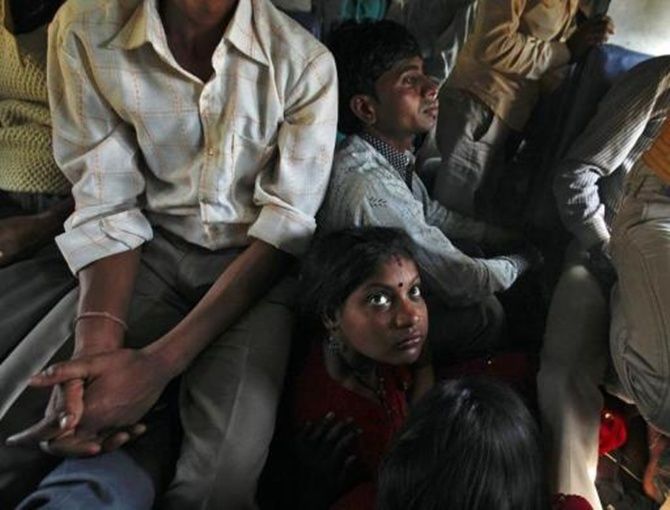 Passengers sit on the floor while traveling inside an overcrowded general class compartment of the Kalka Mail train in Kanpur.