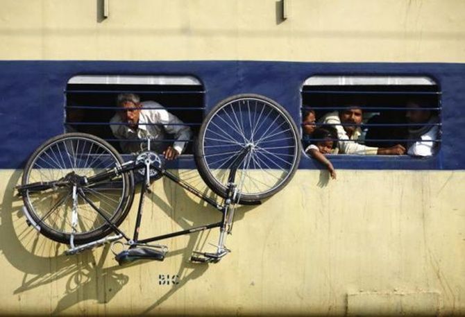 A bicycle hangs from the window of a train at Parsha Bazar railway station in Bihar.