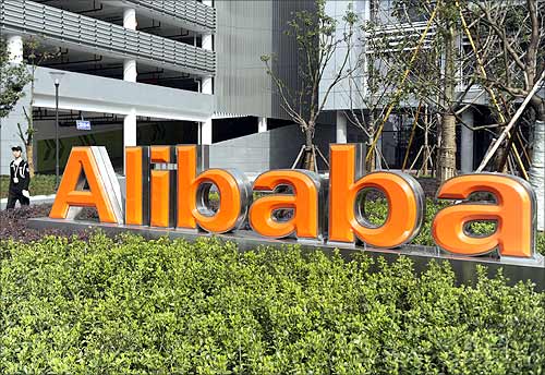 A security guard walks past a logo of Alibaba (China) Technology Co. Ltd at its headquarters on the outskirts of Hangzhou.